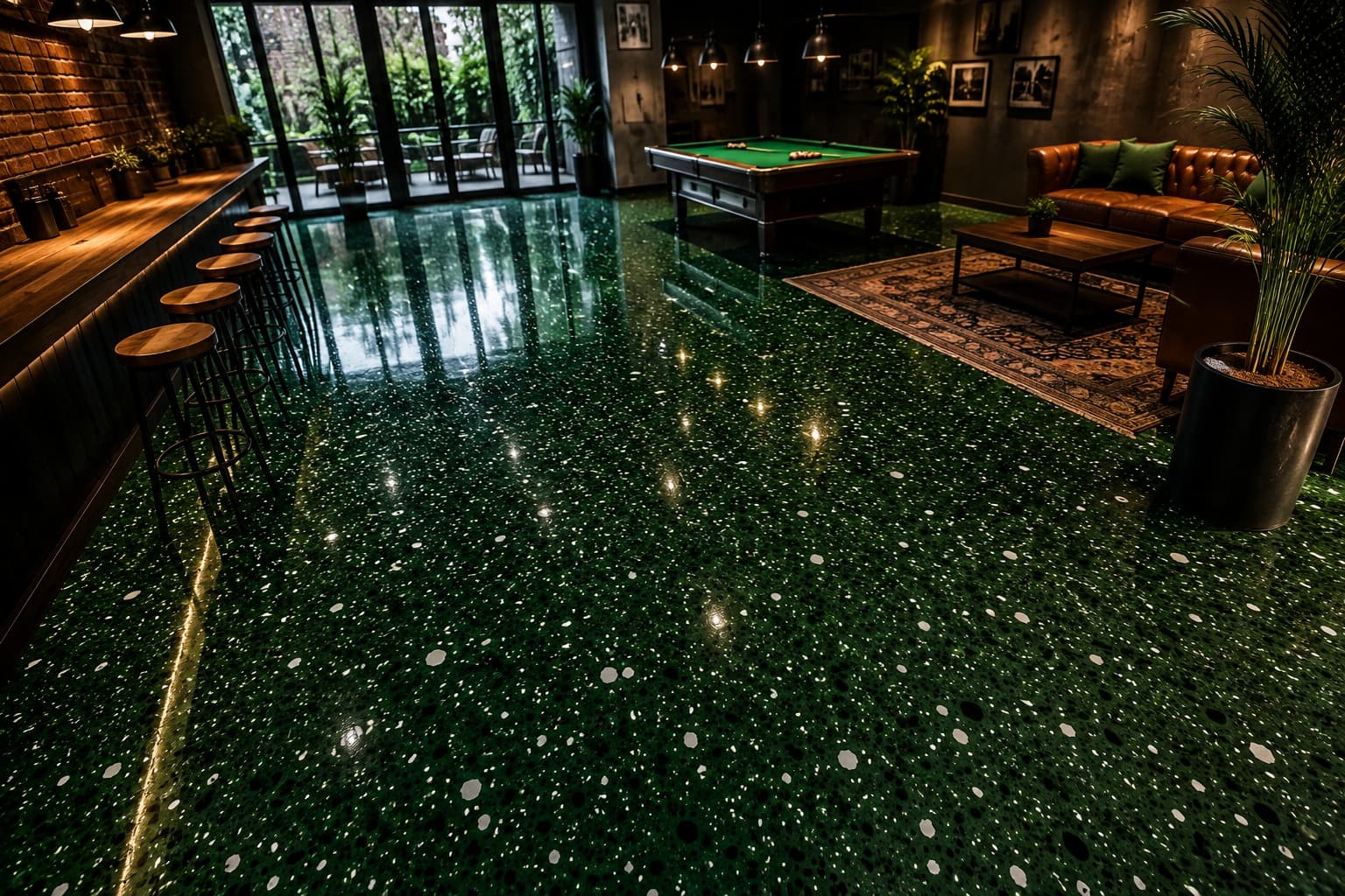 Deep green flake epoxy floor in a basement games room, running from the bar stools past the pool table