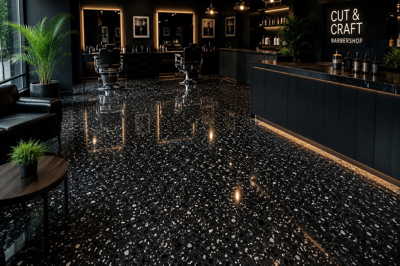 Black flake epoxy floor with white flakes in a barbershop, its clear topcoat mirroring the chairs and warm counter lighting